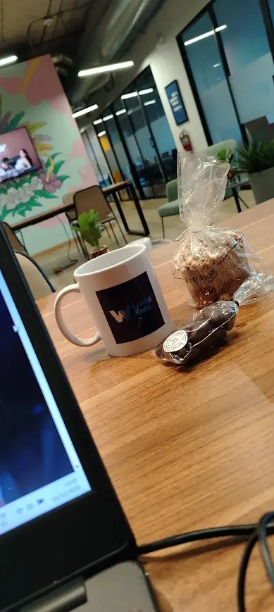 Mesa de trabajo de Lady Web con computadora, café y materiales durante la preparación de un proyecto